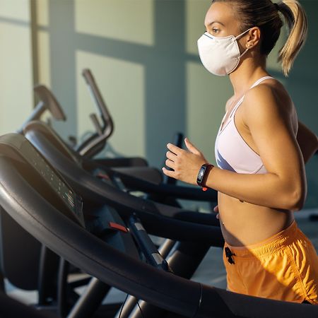 Voco Dubai By Ihg Hotel Exterior photo A woman wearing a face mask while exercising on a treadmill
