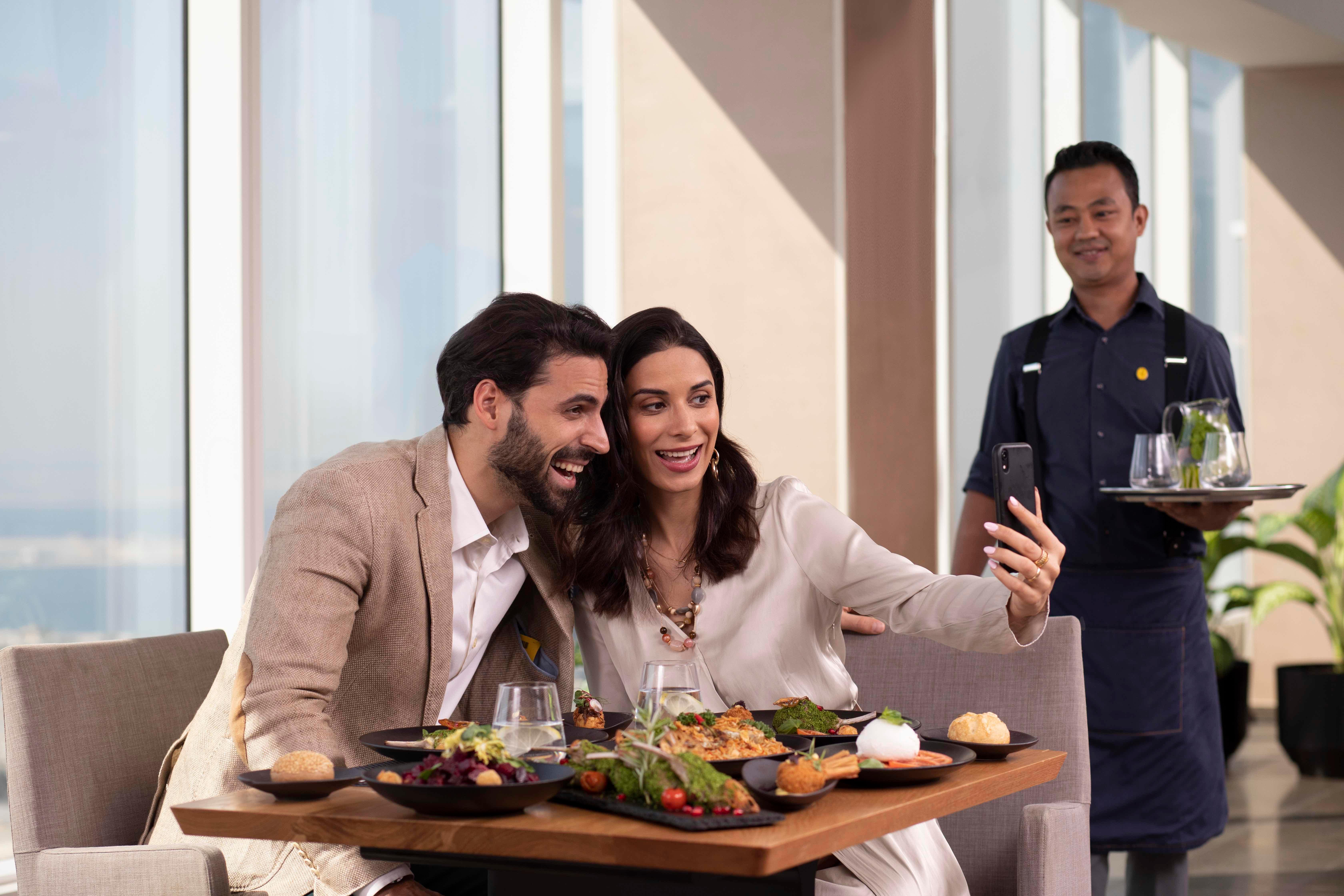 Voco Dubai By Ihg Hotel Exterior photo A waiter serving a couple