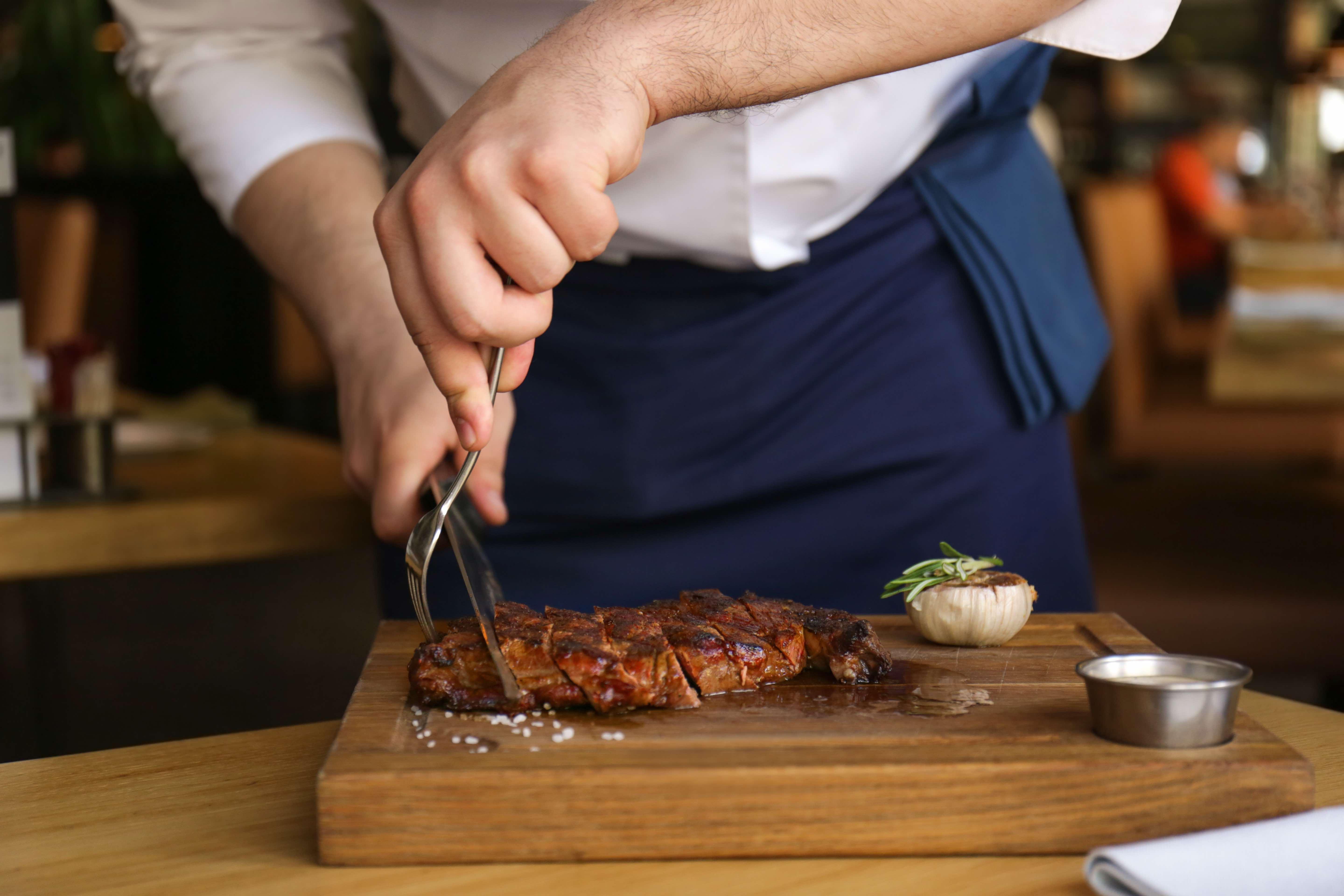 Voco Dubai By Ihg Hotel Exterior photo A chef cutting a steak