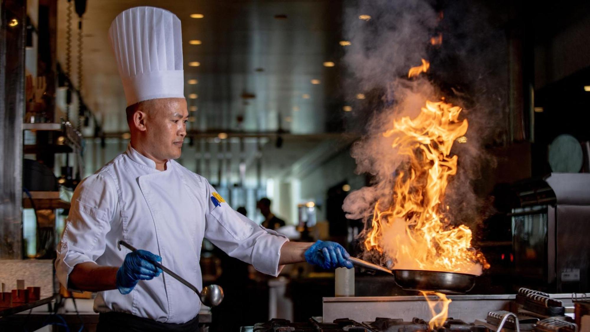 Voco Dubai, An Ihg Hotel Exterior photo A chef cooking with a flaming wok